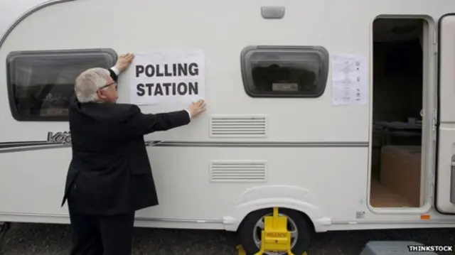 A clerk puts up polling station signs