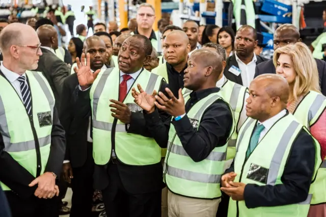 South Africa"s President Cyril Ramaphosa (2L) speaks with workers during a visit to the Volvo Automobile factory plant in Durban on May 19, 2018