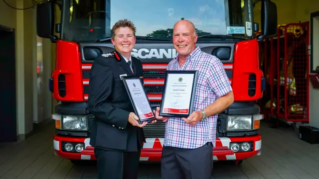 Chief Fire Officer Becci Bryant presents Geoffrey Handley with his commendation certificate