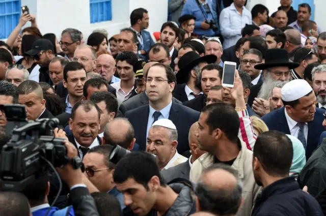 Tunisian Prime Minister Youssef Chahed (C) visits the Ghriba Synagogue on the Tunisian resort island of Djerba on May 2, 2018