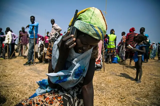 A woman from Thonyor, South Sudan, uses a satellite phone provided by ICRC (International Committee of the Red Cross) on February 3, 2016 to call her lost relatives, who fled the village in October 2015