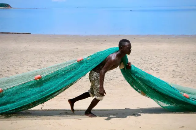 A fisherman pulls a net on the main beach on March 8, 2018 in Mocimboa da Praia, Mozambique