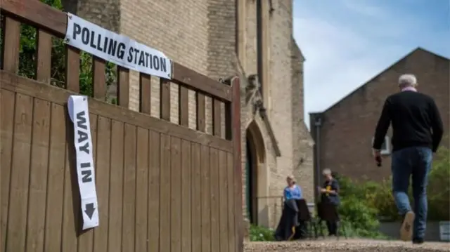 Voters head into a polling station at a church in Twickenham