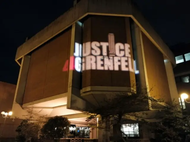 The logo of campaign group Justice 4 Grenfell is beamed onto Kensington Town Hall as voted at the local election are counted