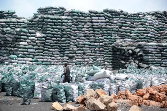 Photo taken on February 27, 2013 shows a Somali worker filling a sack with charcoal as they are prepared for transportation near the Kismayo seaport