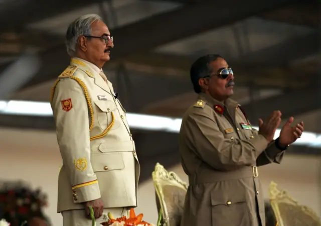 Libyan Strongman Khalifa Haftar (L) attends a military parade in the eastern city of Benghazi on May 7, 2018