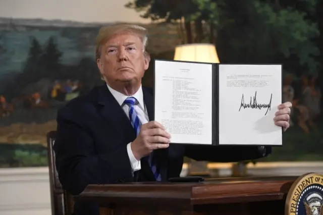 Trump holds up signed document