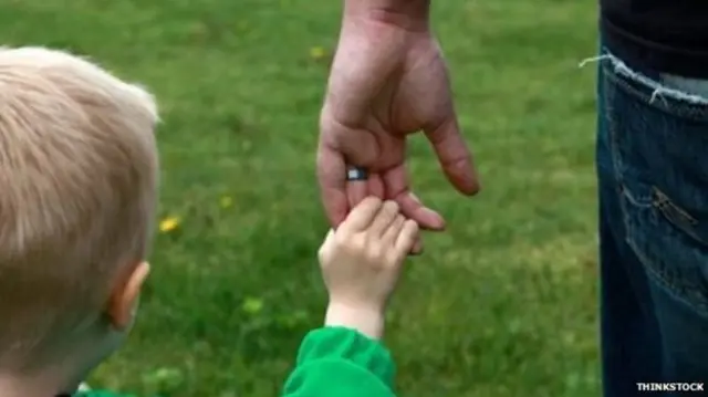 A child holding an adults hand