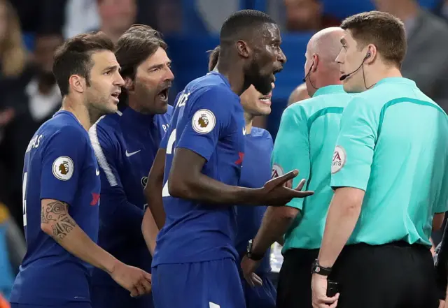 Chelsea players surround referee Lee Mason