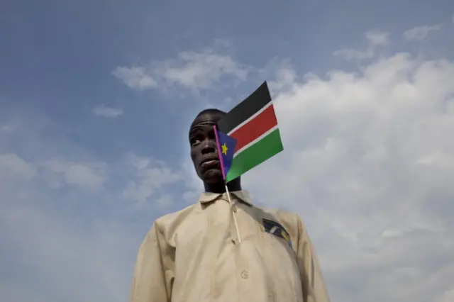 A Sudanese man holds the national flag attending a cultural festival to celebrate the South Sudan's anniversary July 7, 2012 in Juba, South Sudan