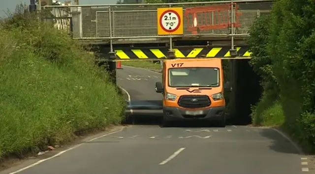 Van stuck under bridge