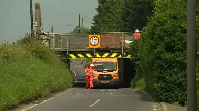Van stuck under bridge