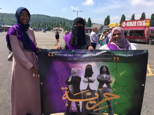 Group of Muslim women holding their banner