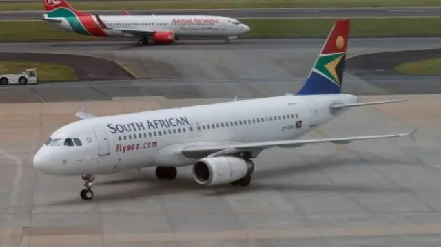 A South African Airways aircraft (bottom) arrives as a Kenya Airways aircraft prepares to take off at the OR Tambo International Airport in Johannesburg, South Africa, March 8, 2017