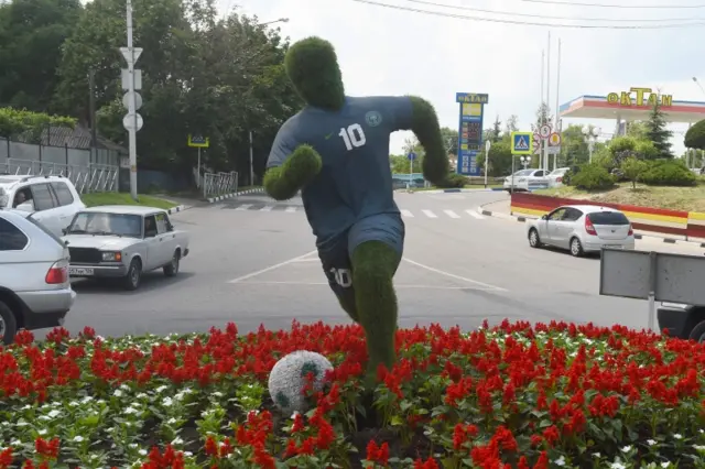 Motorists drive past an artwork featuring a Nigerian footballer displayed to welcome Nigeria"s national football team to their base camp in Essentuki, southern Russia on June11, 2018, ahead of Russia 2018 World Cup football tournament.