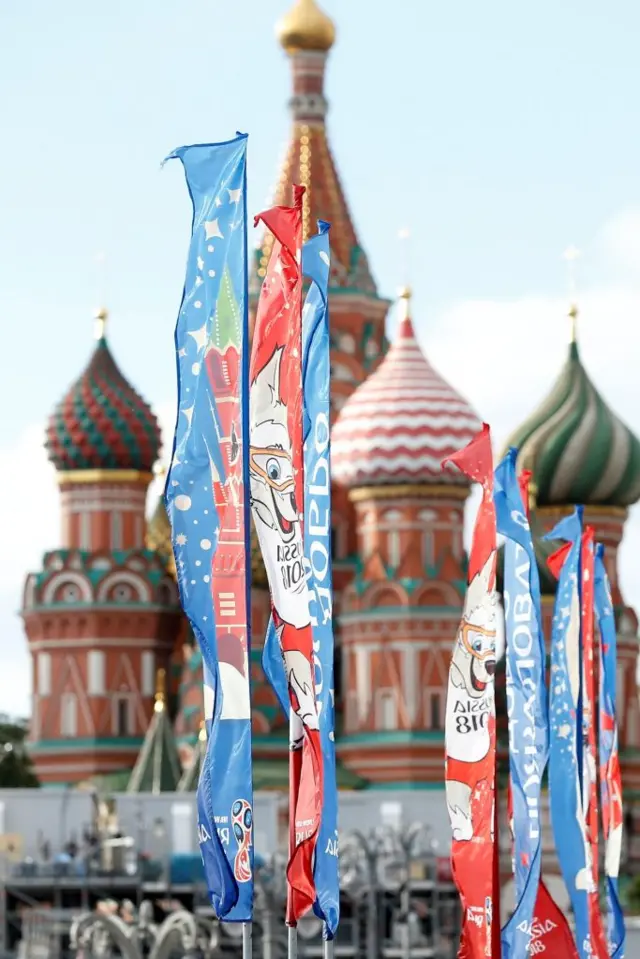 People walk front of flag with the logo of the FIFA World Cup 2018 in Moscow before the 2018 FIFA World Cup Russia in Moscow, Russia on June, 2018