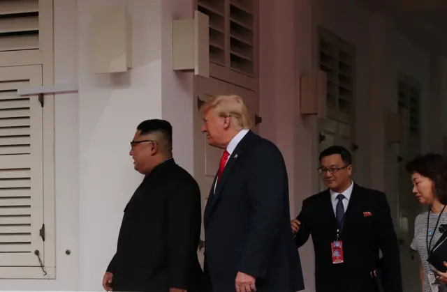 U.S. President Donald Trump walks with North Korean leader Kim Jong Un at the Capella Hotel on Sentosa island in Singapore June 12, 2018.