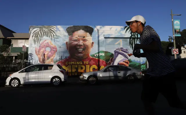 A man skates by a mural in LA's Koreatown neighbourhood