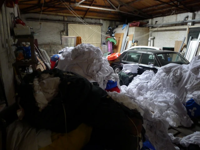 A messy garage full of laundry and other junk