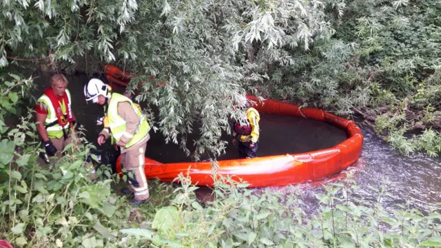 Firefighters around one of the booms