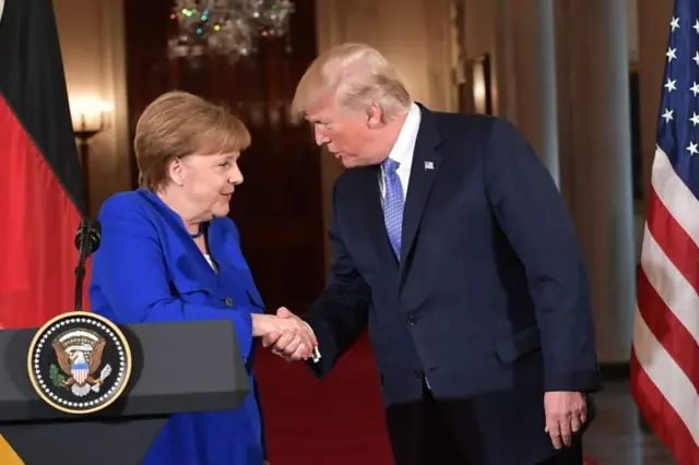 Angela Merkel shakes hands with Donald Trump