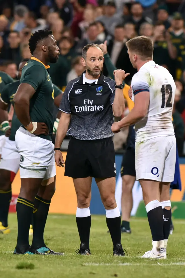 Romain Poite speaks to the captains