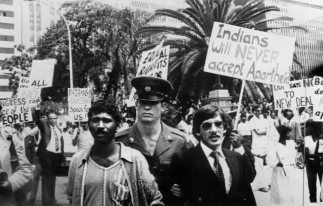 A policeman arrests two indian men of South Africa, on November 14, 1983 during a demonstration against apartheid outside Durban city Hall.