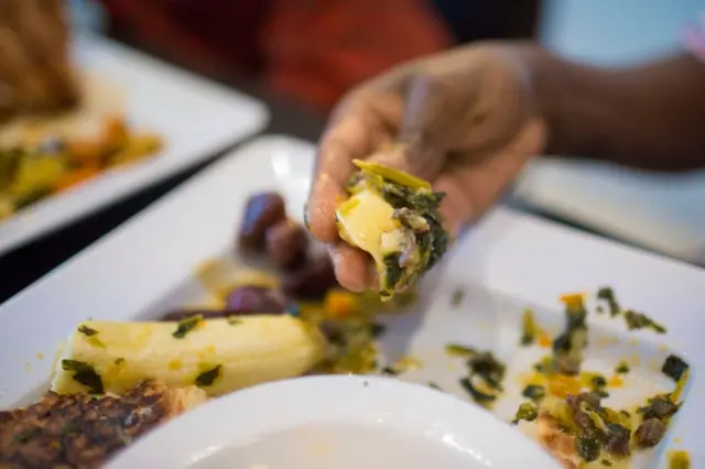 A man eats Somali food in a restaurant in Toronto, Canada.