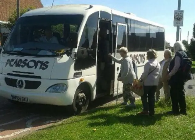 Passengers getting on the mini bus.