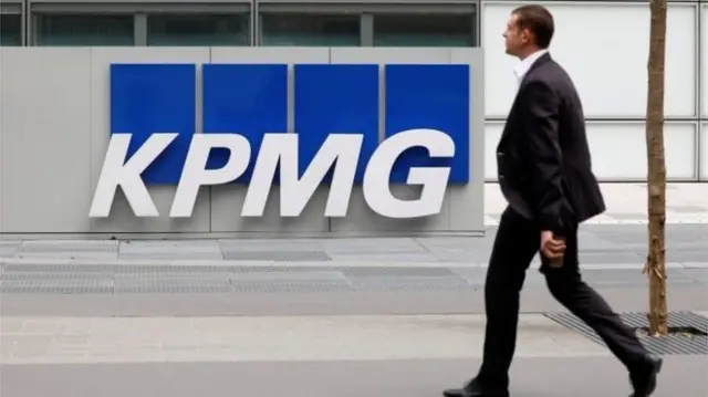 Man walking past KPMG sign