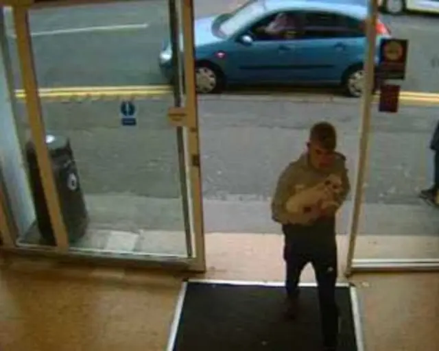 CCTV of man carrying a dog