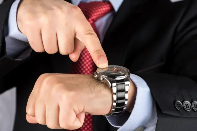 A man points at a watch