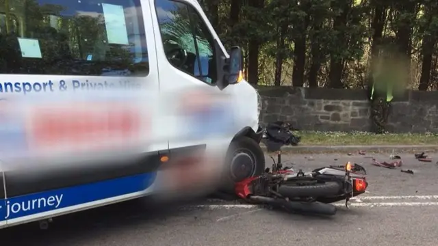 Bike trapped under minibus