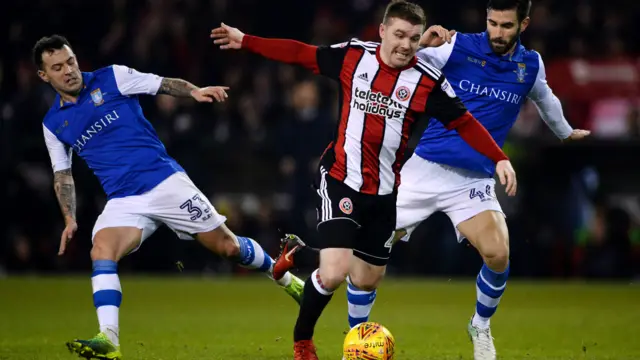 Two Sheffield Wednesday players tackle and Sheffield united player