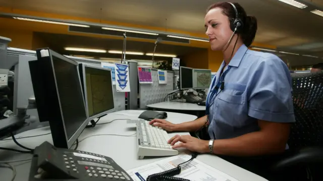 Police call handler answers phone in a call centre