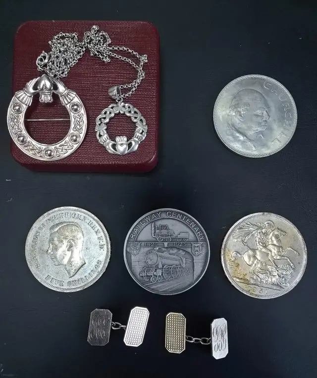 Four coins and a brooch