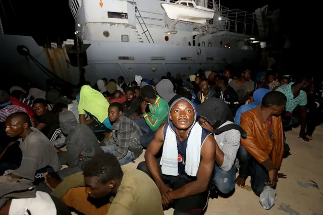 Migrants wait at a naval base in Tripoli, after being rescued in the Mediterranean on June 24, 2018.