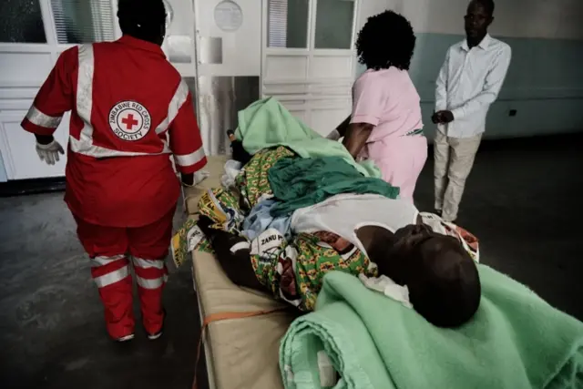 An injured ZANU-PF party supporter lies on a stretcher bed covered in blood as nurses move him to the intensive care unit at Mpilo hospital on 23 June 2018 in Bulawayo