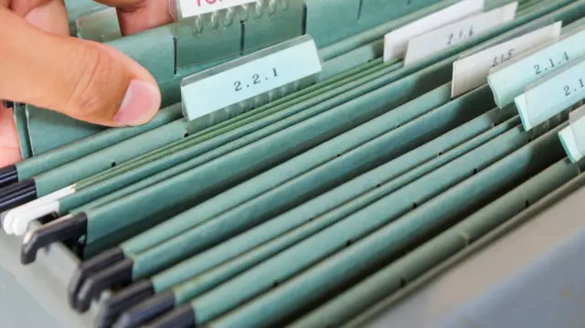 A person looking in a filing cabinet