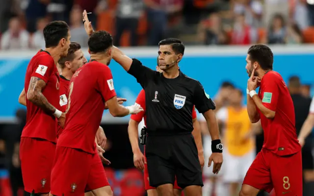 Portugal players complain after a penalty is awarded to Iran