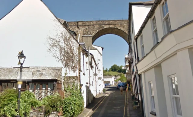 narrow village street with viaduct in background