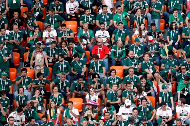 Mexico supporters checking their phones in the stands