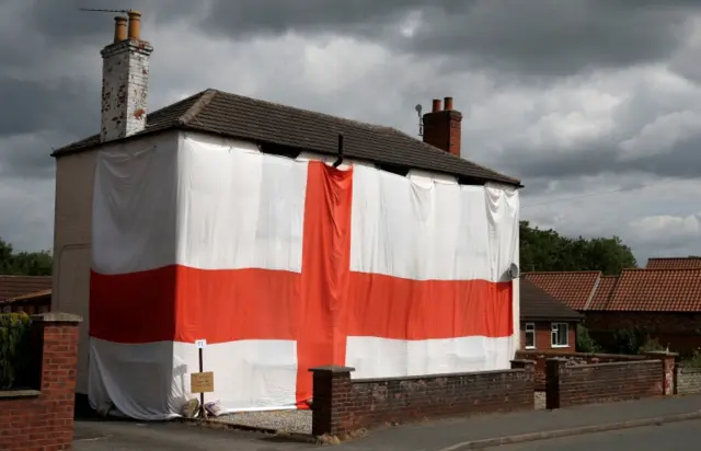 A house can be seen draped in a huge St George Cross England flag in Blyton, Lincolnshire