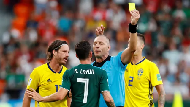 Mexico's Miguel Layun is shown a yellow card by referee Nestor Pitana