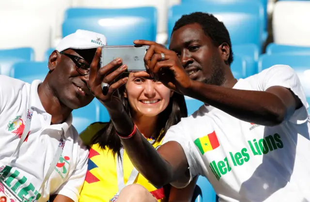 Two Senegalese fans and a Colombian fan taking a selfie in the stadium in the Russian city of Samara