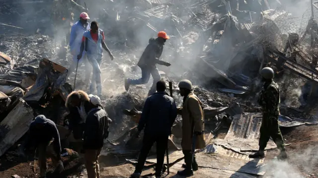 Riot police evict traders at the smouldering scene of fire that gutted  Gikomba market, Nairobi, Kenya - 28 June 2018