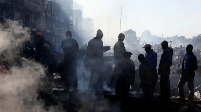 Traders at the smouldering scene of fire that gutted  Gikomba market, Nairobi, Kenya - 28 June 2018