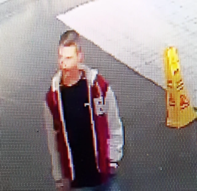 CCTV image of man in red jacket