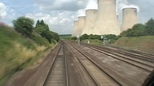 Train passes cooling towers