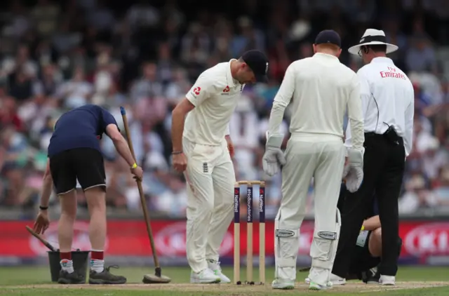 The groundsman inspect the bowling crease